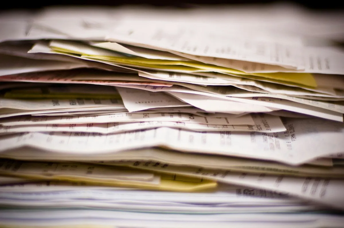 Close-up of a tall, messy stack of invoices and receipts